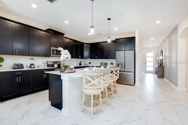 8982 Cabot Cliffs Dr, Davenport, FL 33896 - kitchen featuring stainless steel appliances, light marble finish floors, recessed lighting, light countertops, and a breakfast bar area