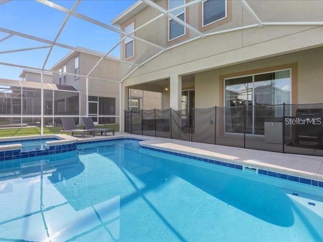 8982 Cabot Cliffs Dr, Davenport, FL 33896 - view of pool with a pool with connected hot tub, glass enclosure, and a patio area