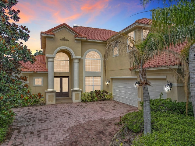 2209 Callaway Ct, Davenport, FL 33837 - mediterranean / spanish-style house featuring french doors, stucco siding, decorative driveway, and a tiled roof