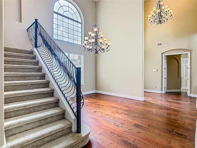 2209 Callaway Ct, Davenport, FL 33837 - stairway featuring a chandelier, a high ceiling, hardwood / wood-style floors, and arched walkways