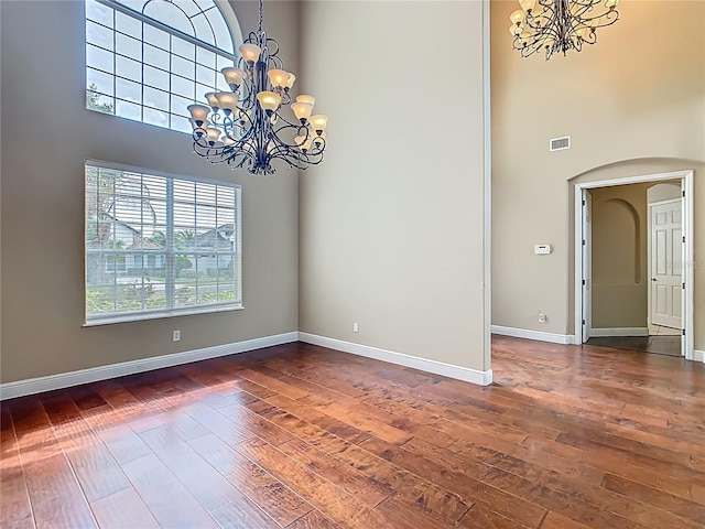 2209 Callaway Ct, Davenport, FL 33837 - spare room with a chandelier, a high ceiling, hardwood / wood-style floors, and arched walkways