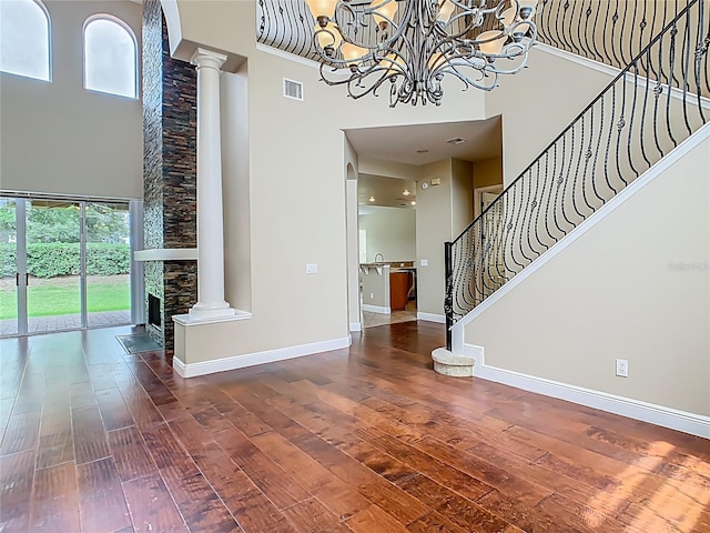 2209 Callaway Ct, Davenport, FL 33837 - foyer entrance featuring a towering ceiling, decorative columns, hardwood / wood-style floors, stairway, and a chandelier