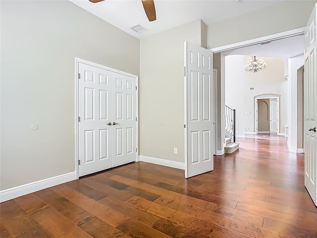 2209 Callaway Ct, Davenport, FL 33837 - unfurnished bedroom featuring arched walkways, hardwood / wood-style floors, a chandelier, and ceiling fan