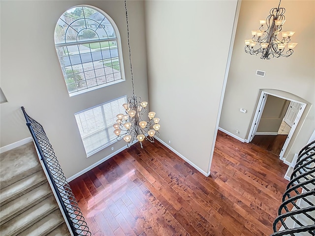 2209 Callaway Ct, Davenport, FL 33837 - foyer entrance featuring a chandelier, dark wood-style flooring, a high ceiling, and arched walkways