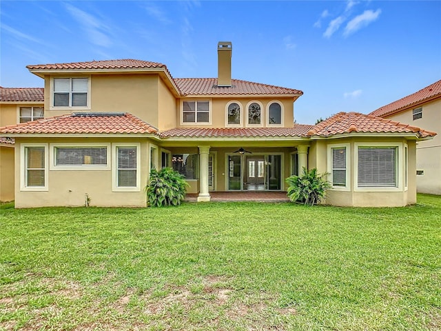2209 Callaway Ct, Davenport, FL 33837 - back of property with a chimney, stucco siding, a yard, a tile roof, and a ceiling fan