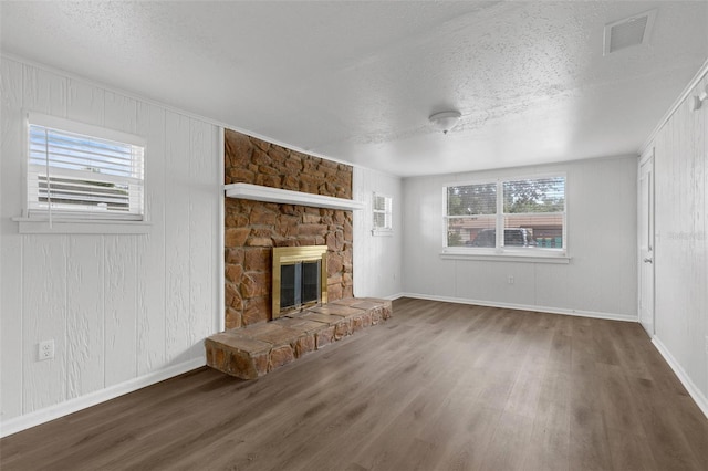 203 E Lakeview Ave, Eustis, FL 32726 - unfurnished living room featuring wood finished floors, a textured ceiling, and a fireplace