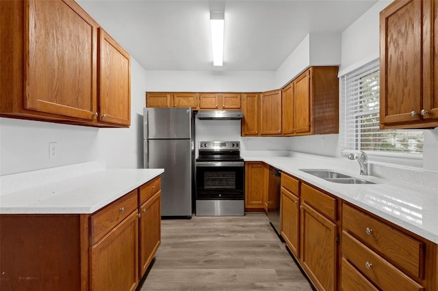 203 E Lakeview Ave, Eustis, FL 32726 - kitchen featuring stainless steel appliances, light wood-type flooring, under cabinet range hood, brown cabinets, and light countertops