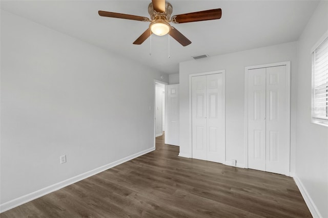 203 E Lakeview Ave, Eustis, FL 32726 - unfurnished bedroom with multiple closets, dark wood finished floors, and ceiling fan