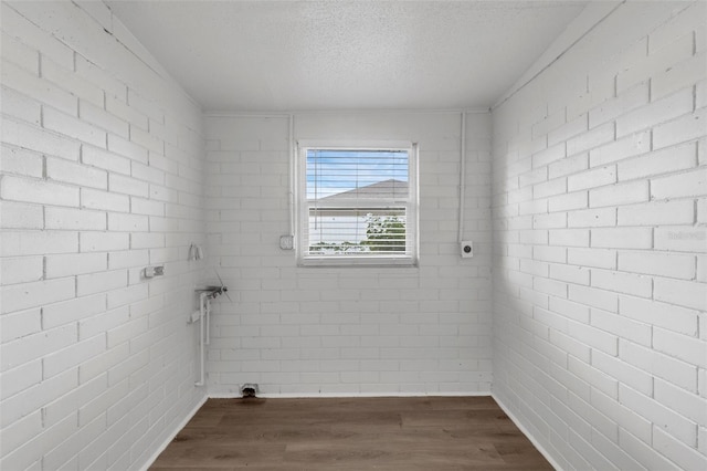 203 E Lakeview Ave, Eustis, FL 32726 - laundry area featuring dark wood-type flooring, a textured ceiling, and brick wall