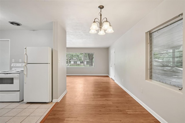 518 NW 36th Ter, Gainesville, FL 32607 - kitchen featuring white appliances, a chandelier, light wood-style flooring, and pendant lighting