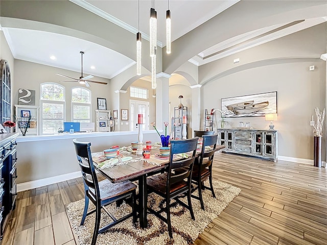 31980 Geoff Way, Sorrento, FL 32776 - dining space with crown molding, arched walkways, decorative columns, a ceiling fan, and light wood-style flooring