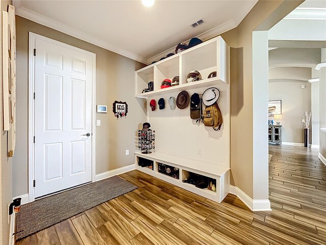 31980 Geoff Way, Sorrento, FL 32776 - mudroom featuring wood finished floors, arched walkways, and ornamental molding