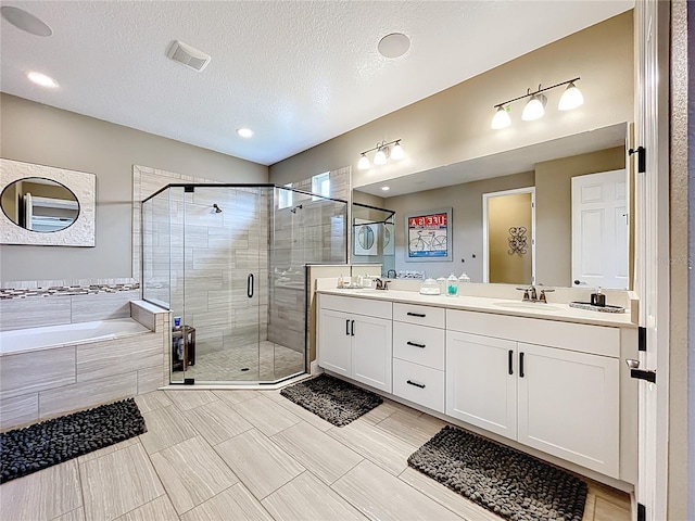 31980 Geoff Way, Sorrento, FL 32776 - bathroom featuring a shower stall, a bath, double vanity, and a textured ceiling