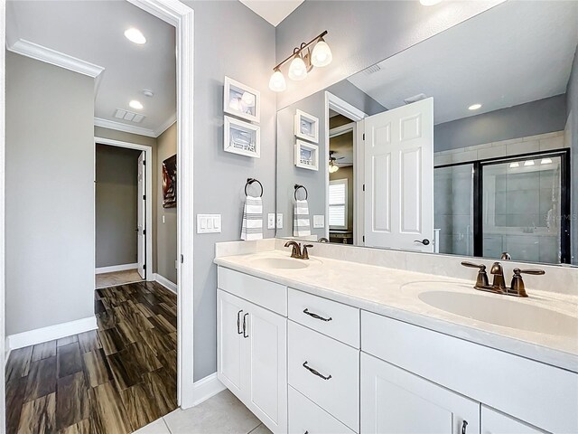 31980 Geoff Way, Sorrento, FL 32776 - full bathroom with double vanity, a shower stall, ornamental molding, and recessed lighting