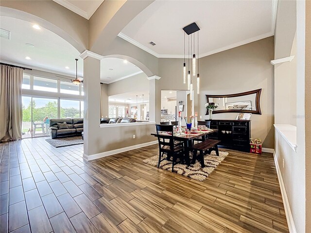 31980 Geoff Way, Sorrento, FL 32776 - dining area featuring ornate columns, arched walkways, ornamental molding, and wood finished floors