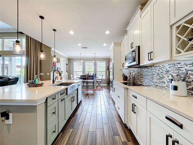 31980 Geoff Way, Sorrento, FL 32776 - kitchen with appliances with stainless steel finishes, light countertops, ornamental molding, tasteful backsplash, and an island with sink