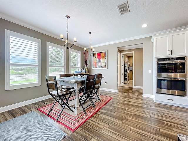 31980 Geoff Way, Sorrento, FL 32776 - dining room with a chandelier, crown molding, light wood finished floors, a textured ceiling, and recessed lighting