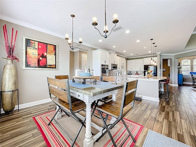 31980 Geoff Way, Sorrento, FL 32776 - dining area with a chandelier, ornamental molding, light wood-type flooring, and recessed lighting