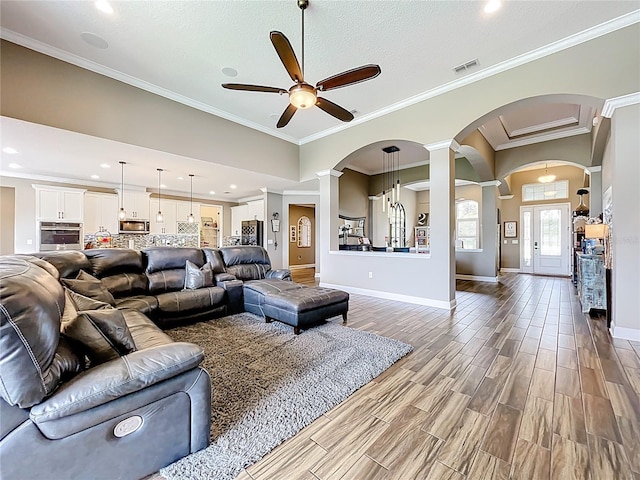 31980 Geoff Way, Sorrento, FL 32776 - living room featuring a ceiling fan, ornate columns, arched walkways, wood finished floors, and ornamental molding