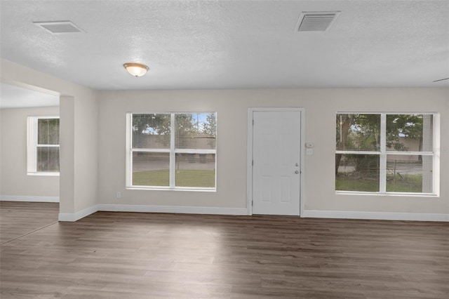7612 Pomelo Dr, Orlando, FL 32819 - foyer featuring healthy amount of natural light, wood finished floors, and a textured ceiling