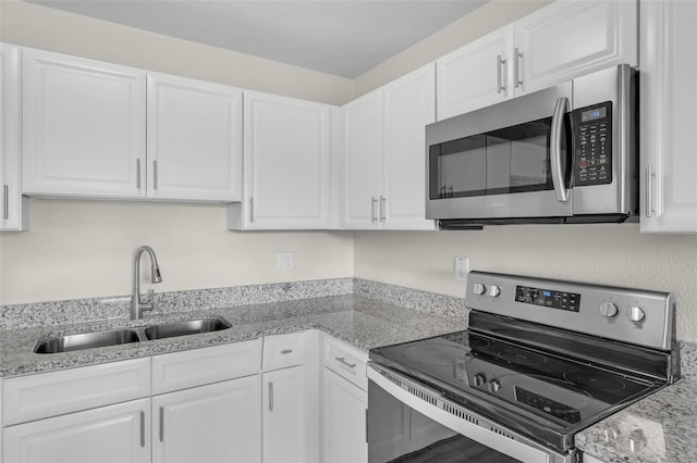 7612 Pomelo Dr, Orlando, FL 32819 - kitchen featuring stainless steel appliances, white cabinetry, and light stone counters