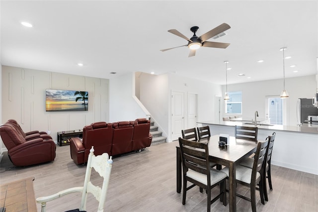 3099 Ella Way, Saint Cloud, FL 34771 - dining area with light wood finished floors, stairway, a ceiling fan, and recessed lighting