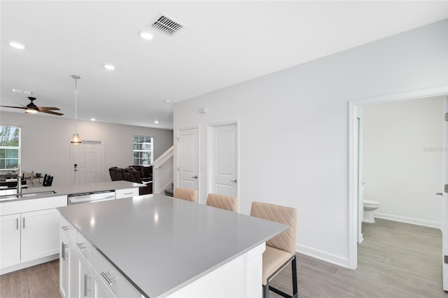 3099 Ella Way, Saint Cloud, FL 34771 - kitchen with a ceiling fan, a breakfast bar, a kitchen island, recessed lighting, and white cabinetry