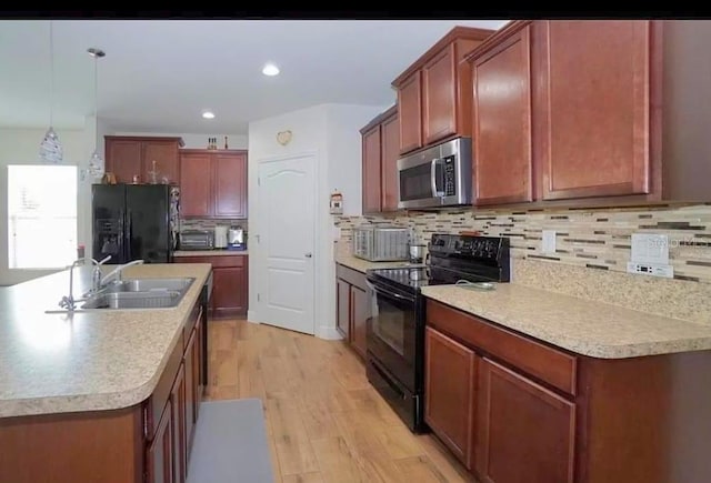 1588 Diamond Loop Dr, Kissimmee, FL 34744 - kitchen with black appliances, light wood-style flooring, decorative backsplash, light countertops, and recessed lighting