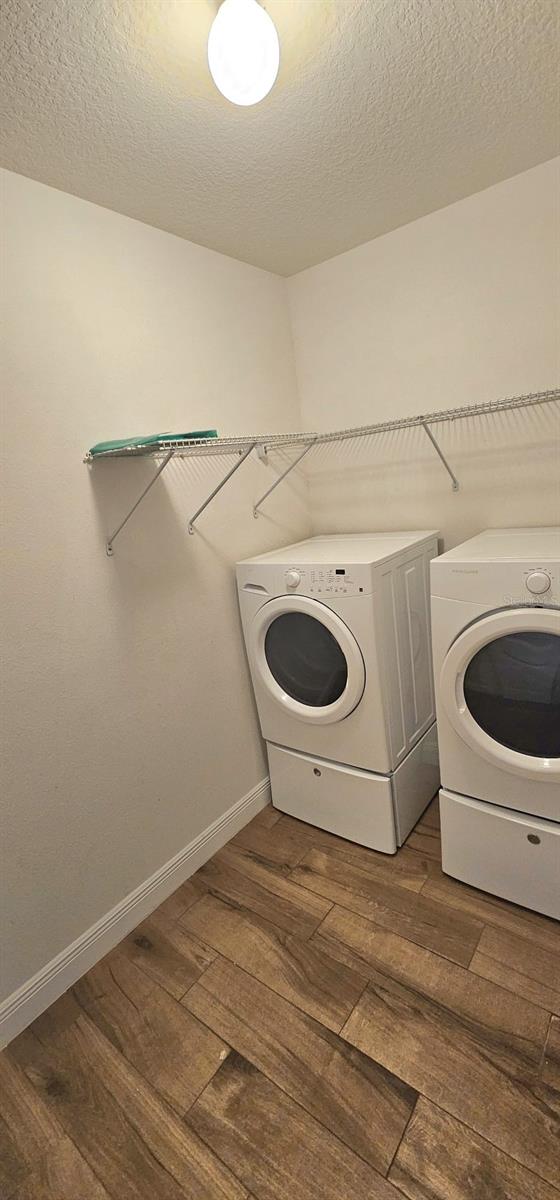 1588 Diamond Loop Dr, Kissimmee, FL 34744 - washroom featuring washing machine and dryer, wood finished floors, and a textured ceiling