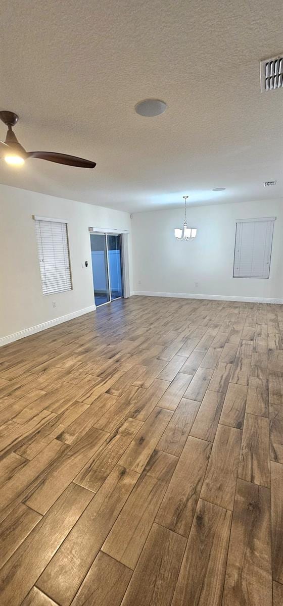 1588 Diamond Loop Dr, Kissimmee, FL 34744 - empty room featuring wood finished floors, a textured ceiling, and a chandelier