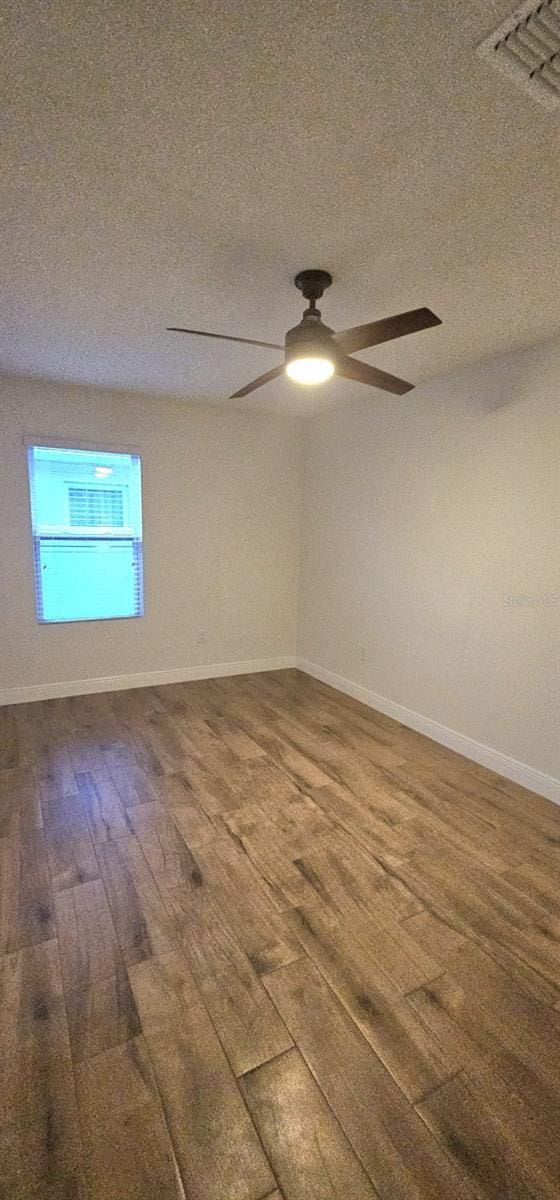 1588 Diamond Loop Dr, Kissimmee, FL 34744 - spare room featuring wood finished floors, ceiling fan, and a textured ceiling