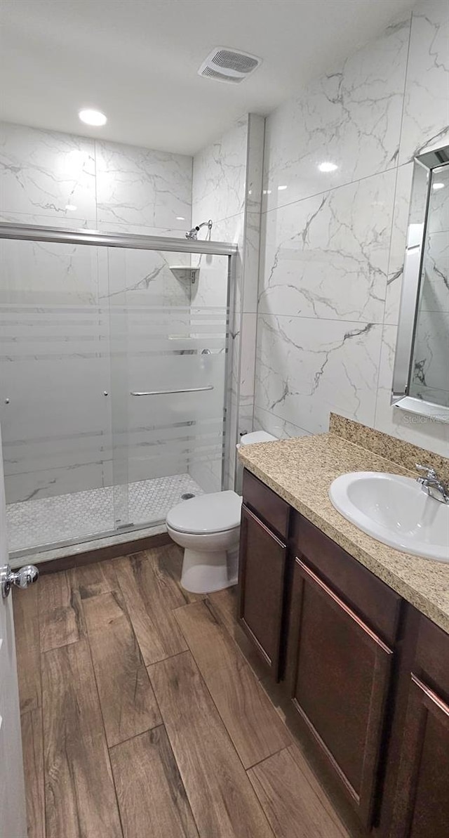 1588 Diamond Loop Dr, Kissimmee, FL 34744 - bathroom featuring vanity, a marble finish shower, wood finished floors, and tile walls