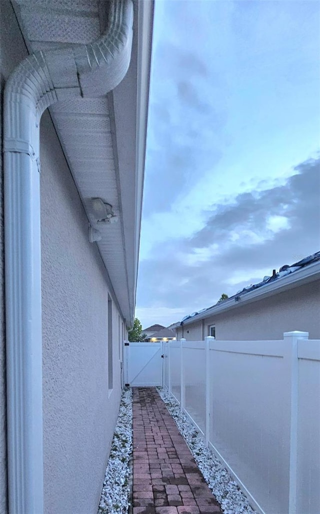 1588 Diamond Loop Dr, Kissimmee, FL 34744 - view of side of home with stucco siding and a gate