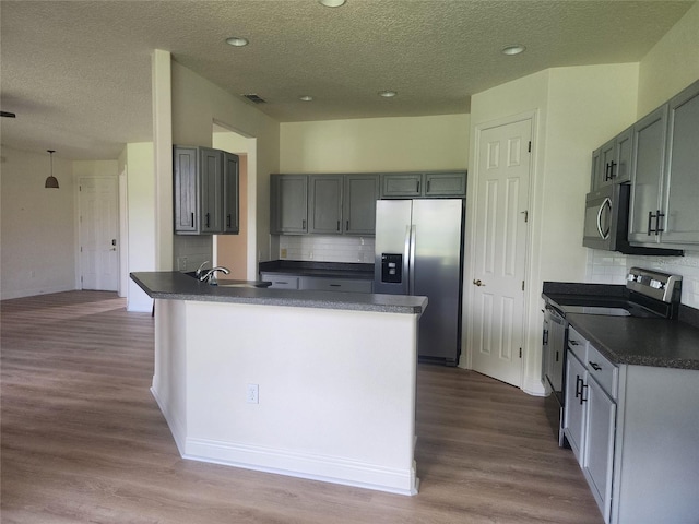 152 Glendale Ct, Kissimmee, FL 34759 - kitchen featuring stainless steel appliances, dark countertops, dark wood-type flooring, tasteful backsplash, and a textured ceiling