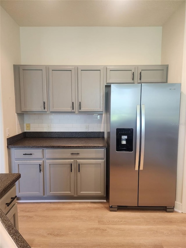 152 Glendale Ct, Kissimmee, FL 34759 - kitchen featuring stainless steel fridge, gray cabinetry, dark countertops, light wood-type flooring, and backsplash