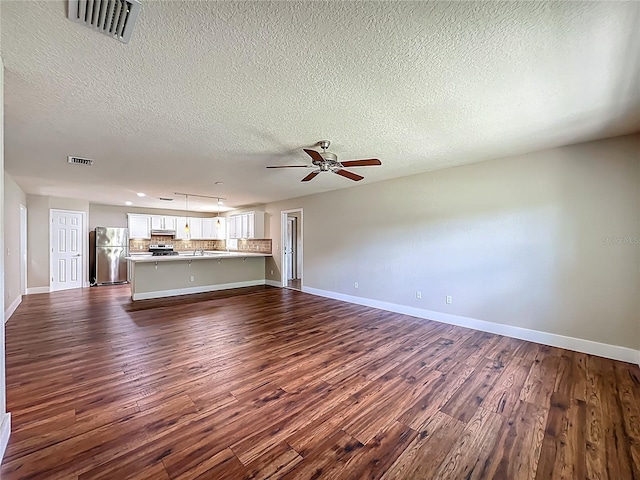 117 Burns Ave, Longwood, FL 32750 - unfurnished living room with dark wood-type flooring, a textured ceiling, and ceiling fan