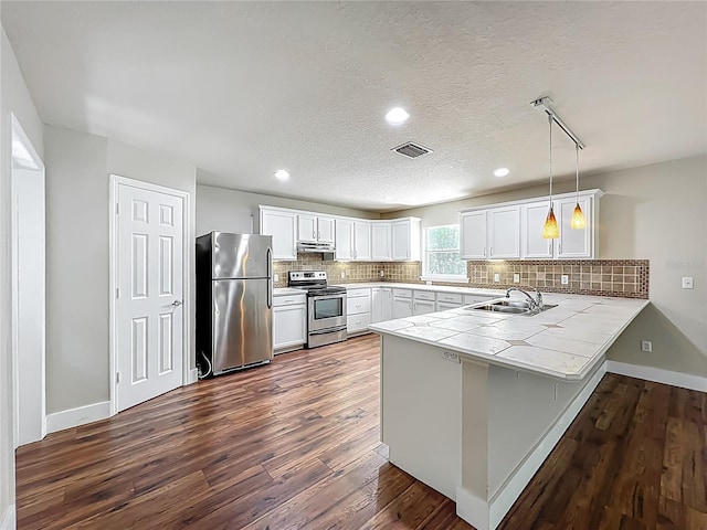 117 Burns Ave, Longwood, FL 32750 - kitchen featuring stainless steel appliances, a peninsula, dark wood-style flooring, decorative backsplash, and recessed lighting