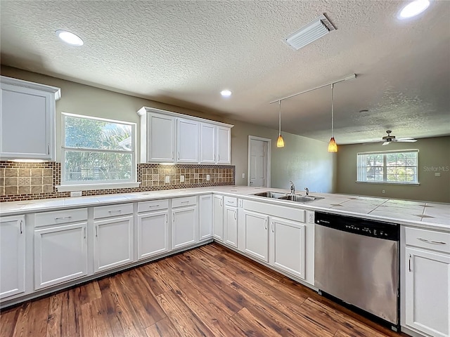 117 Burns Ave, Longwood, FL 32750 - kitchen with stainless steel dishwasher, a textured ceiling, dark wood finished floors, light countertops, and white cabinetry
