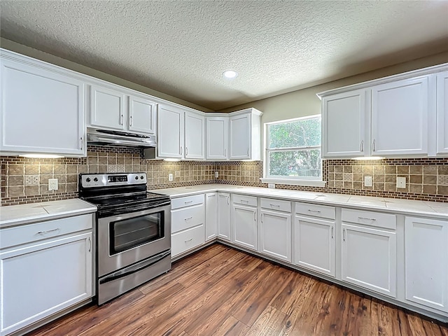 117 Burns Ave, Longwood, FL 32750 - kitchen with stainless steel range with electric cooktop, under cabinet range hood, light countertops, dark wood finished floors, and white cabinetry