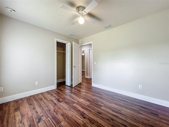 117 Burns Ave, Longwood, FL 32750 - unfurnished bedroom with dark wood-style flooring, a textured ceiling, a closet, and a ceiling fan