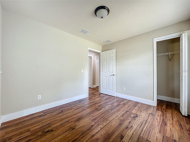 117 Burns Ave, Longwood, FL 32750 - unfurnished bedroom with dark wood-type flooring, a closet, and a textured ceiling