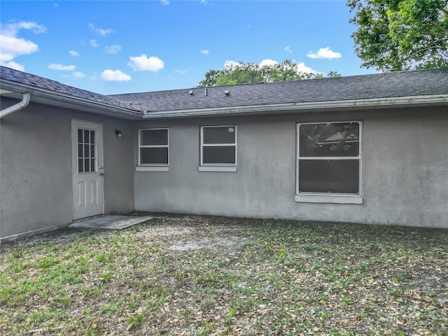 117 Burns Ave, Longwood, FL 32750 - view of home's exterior featuring a shingled roof, stucco siding, and a yard