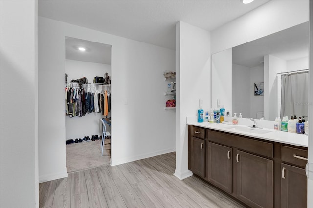 205 Cimarron Dr, Kissimmee, FL 34759 - bathroom with vanity, wood finished floors, a walk in closet, and a shower with shower curtain