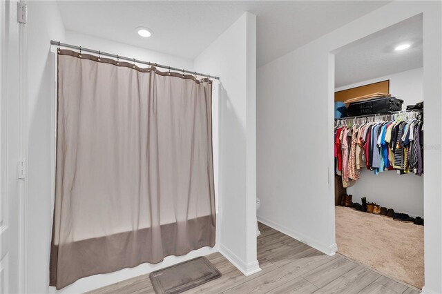 205 Cimarron Dr, Kissimmee, FL 34759 - bathroom featuring wood finished floors, a walk in closet, and recessed lighting
