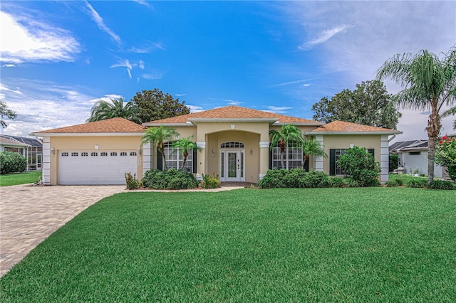 800 Sterling Chase Dr, Port Orange, FL 32128 - mediterranean / spanish house with stucco siding, a garage, french doors, and a front lawn