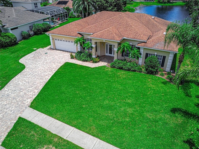 800 Sterling Chase Dr, Port Orange, FL 32128 - mediterranean / spanish-style home with a garage, decorative driveway, a water view, a front lawn, and roof with shingles