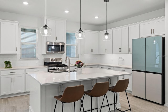 15133 Summer Harvest St, Winter Garden, FL 34787 - kitchen featuring stainless steel appliances, white cabinetry, light countertops, tasteful backsplash, and recessed lighting