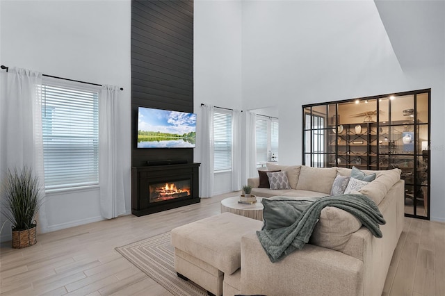 15133 Summer Harvest St, Winter Garden, FL 34787 - living room featuring a towering ceiling, wood finished floors, and a large fireplace