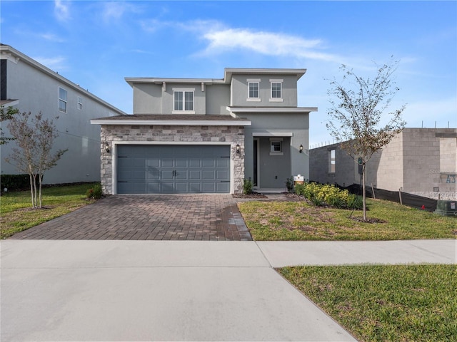 4409 Lions Gate Ave, Clermont, FL 34711 - view of front of property featuring stucco siding, decorative driveway, an attached garage, stone siding, and a front lawn