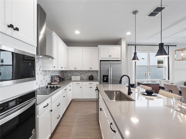 4409 Lions Gate Ave, Clermont, FL 34711 - kitchen featuring stainless steel appliances, wall chimney range hood, white cabinets, decorative backsplash, and recessed lighting